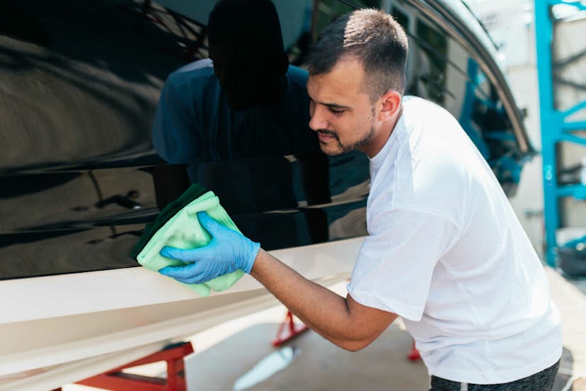 Man wiping the side of his boat with a microfiber towel