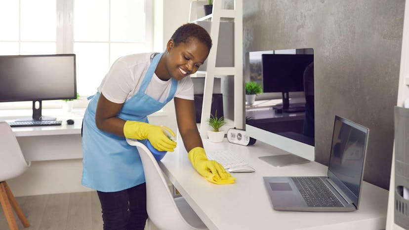 Residential cleaner disinfecting client desk station