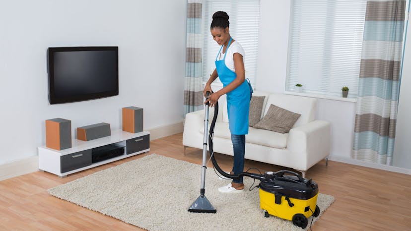 Airbnb cleaner vacuuming living room rug