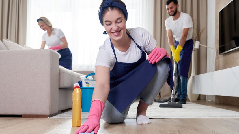 Three vacation rental cleaners smiling as they complete their cleaning tasks