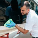 Man cleaning boat with a microfiber towel