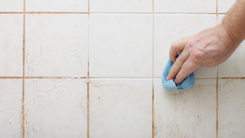 Hand holding a microfiber cloth as dirt from the tile is removed