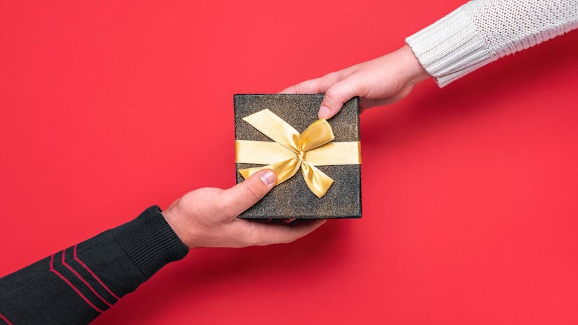 A gift box in the middle with hands grabbing it in an exchange