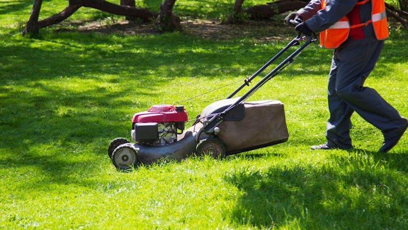 Lawn care employee mowing a clients yard