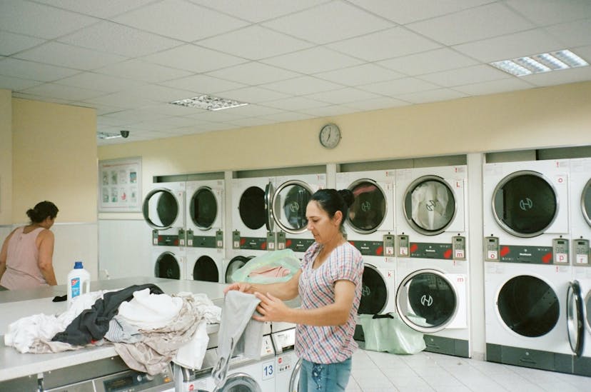 Woman folding her laundry at a laundromat
